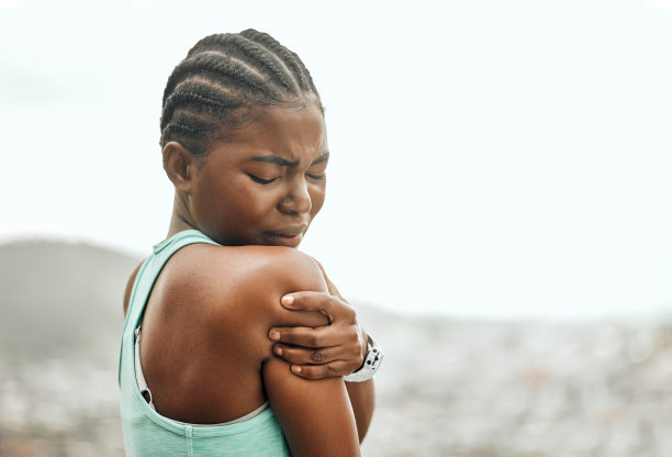 这张照片拍摄的是一位年轻女子在锻炼时因疼痛而挽着手臂图片下载