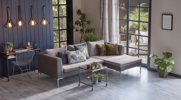 花园景观前的现代灰色沙发和木制背景墙，植物灯花瓶和中间的桌子，家居设计。图片下载