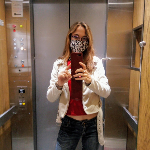 一张年轻女子戴着面具在电梯里自拍的照片图片下载