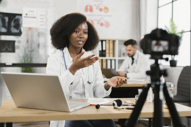 身着白大褂的非洲女医生录制视频博客图片下载