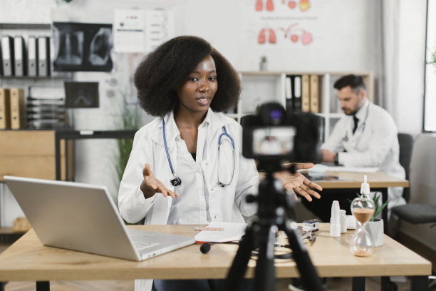 身着白大褂的非洲女医生录制视频博客图片下载