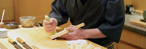 厨师用木刨丝器研磨新鲜的山葵。图片下载