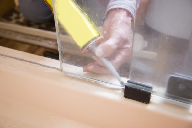 水管工或房主自己动手修理漏水的淋浴门。图片下载