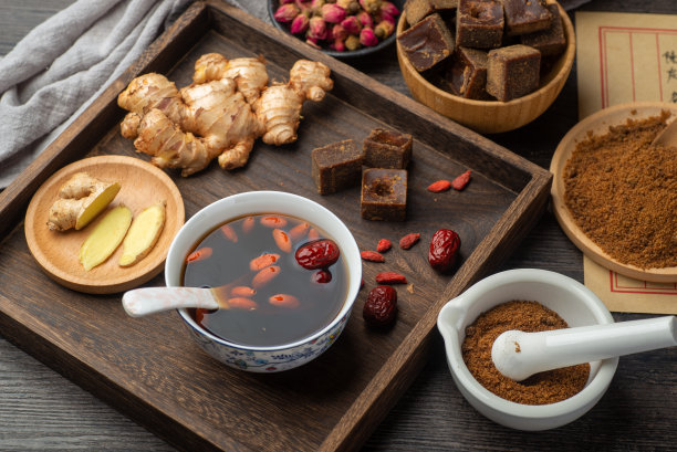 桌上摆着红糖姜枣茶和中医古籍图片下载