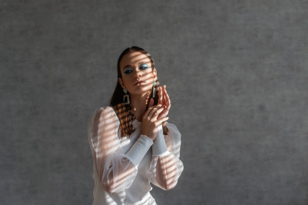 近距离美女肖像的女孩，清洁的皮肤。浅阴影条纹图案在脸上。灰色背景图片下载