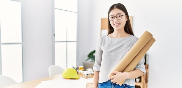 年轻的亚洲女性拿着设计图在办公室图片下载