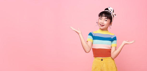 快乐的亚洲儿童女孩微笑的相机在粉红色的拷贝空间背景图片下载