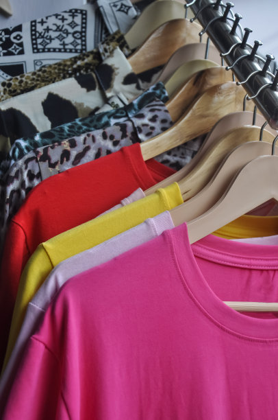 各种颜色的t恤和衬衫挂在商店的衣架上出售-库存照片图片下载