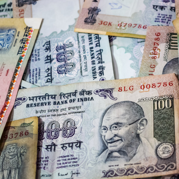 旧的一百卢比合在一起放在桌子上，印度钱在旋转的桌子上。旋转的桌子上放着印度纸币，桌上放着印度货币图片下载