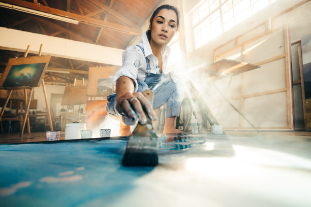 熟练的年轻艺术家用画笔在画布上作画图片下载