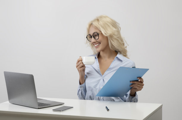 商业生活方式。快乐的上班族喝咖啡，处理文件，在工作场所看笔记本电脑图片下载