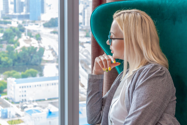 漂亮的女人坐在窗边的椅子上图片下载