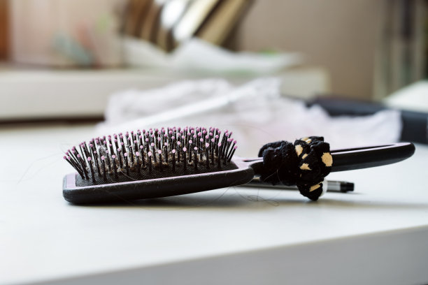 发刷和扎马尾的发带放在桌子上图片下载