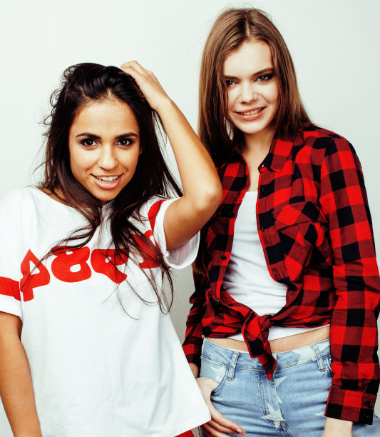 最好的朋友十几岁的女孩在一起有乐趣，在白色的背景下摆出情绪，最好的朋友快乐的微笑，生活方式的人的概念，金发和黑发的多国接近图片下载