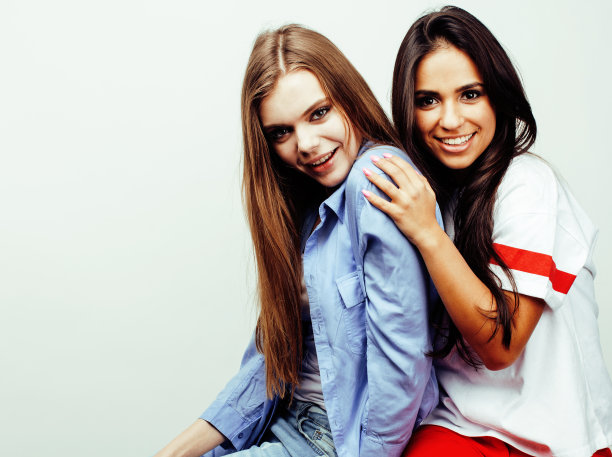 最好的朋友十几岁的女孩在一起有乐趣，在白色的背景下摆出情绪，最好的朋友快乐的微笑，生活方式的人的概念，金发和黑发的多国接近图片下载