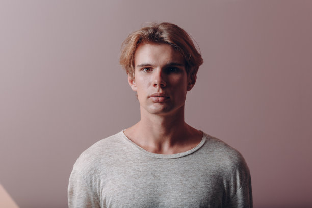 一个年轻人站在画室里。图片下载