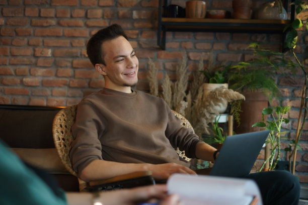 一个年轻人在咖啡馆里和他的笔记本电脑开会图片下载