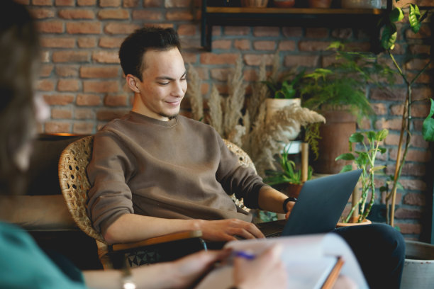 一个年轻人在咖啡馆里和他的笔记本电脑开会图片下载