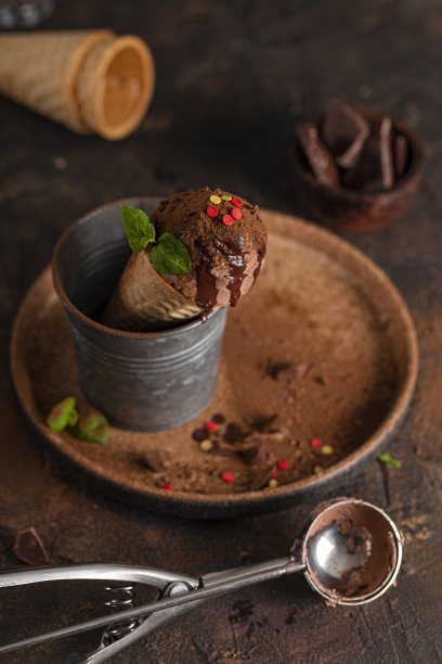 自制巧克力冰淇淋蛋卷配巧克力糖浆和薄荷，垂直照片图片下载