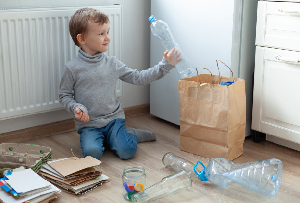 那个男孩在厨房里把垃圾分类。分类纸张、塑料、玻璃。零浪费的概念。3R理念:减少、再利用、回收图片下载