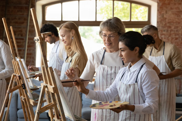 熟练而快乐的老艺术家正在教育年轻的印度妇女。图片下载