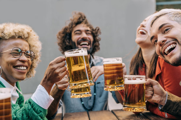 多种族朋友有乐趣，在啤酒厂酒吧餐厅户外啤酒欢呼-关注非洲女孩的手图片下载