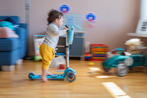 男孩在家里骑滑板车图片下载