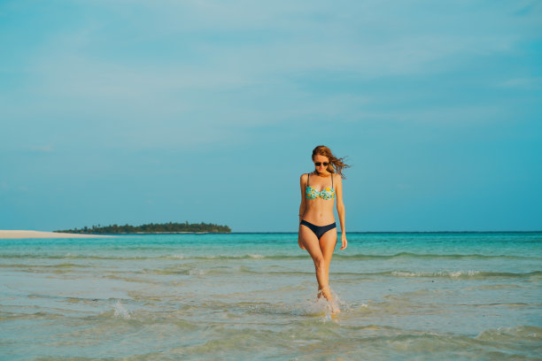 美丽的女人走在热带海滩图片下载