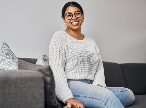 一个年轻女人在家里的沙发上放松的照片图片下载