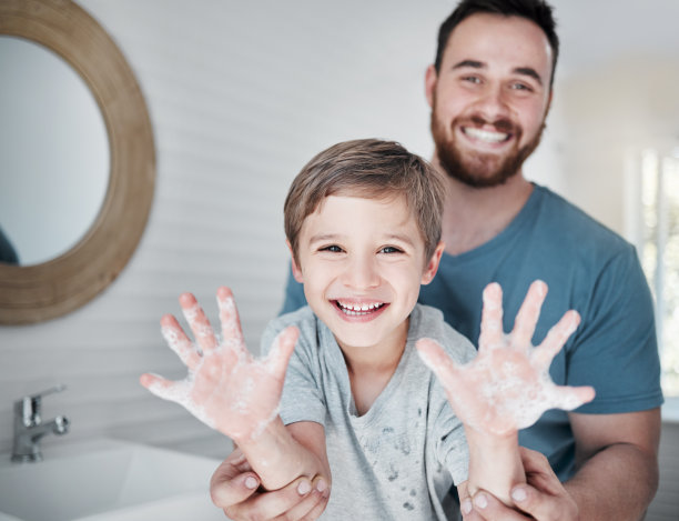 这是一个男孩和他的父亲站在家里的浴室里，举着沾满肥皂的手的照片图片下载