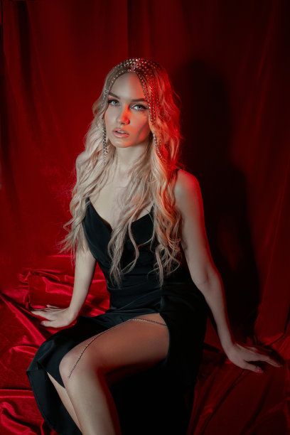 美丽的金发女人，红色天鹅绒背景的长发。女人头上的头发饰品，现代的化妆和眼睛上的箭头图片下载