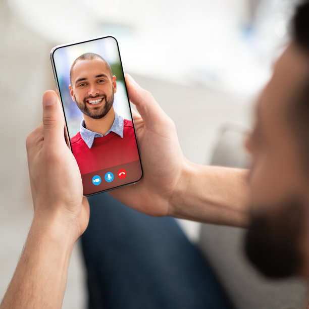 用智能手机与阿拉伯朋友进行远程会议的年轻男人图片下载