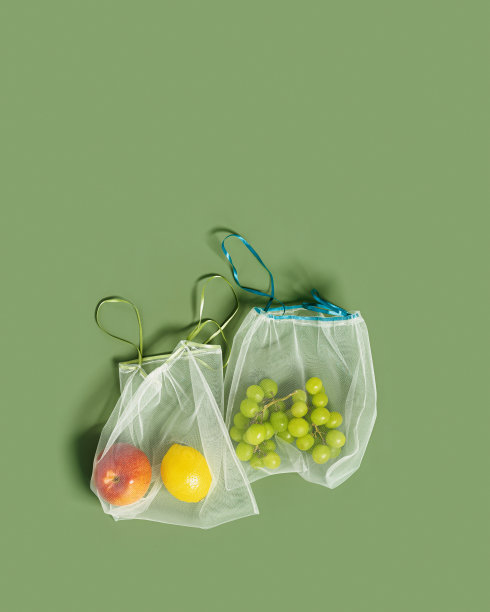 可重复使用的食品袋从水果网，可重复使用的包装水果和蔬菜，生态网袋与丝带，环保和零浪费的概念，以上橄榄色背景图片下载