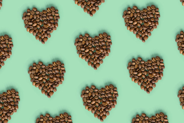 薄荷色背景上的咖啡豆形状心形，烤棕咖啡浆果，时尚的几何图案设计，俯视图，最小的平铺图片下载