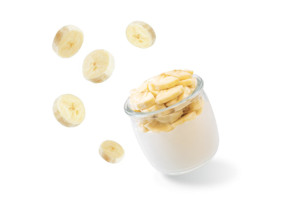 希腊酸奶和香蕉片在一个白色的孤立背景玻璃图片下载