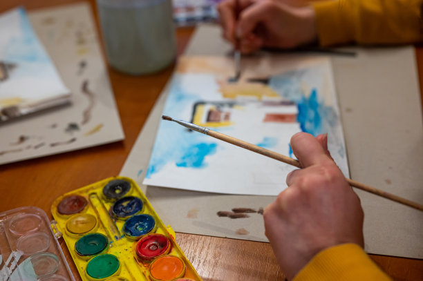 笔刷手上面的水彩画。彩色的中世纪城市街道上的纸板。图片下载