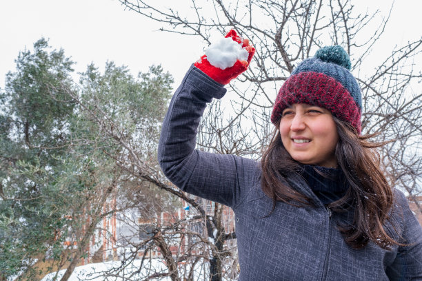 在户外雪地里玩雪球的女士半身照图片下载