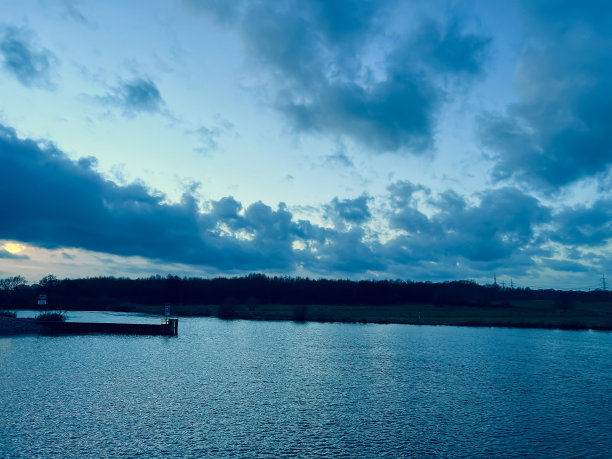 这条河在晚上被称为“Ems”，背景是一片田野和一片森林。图片下载