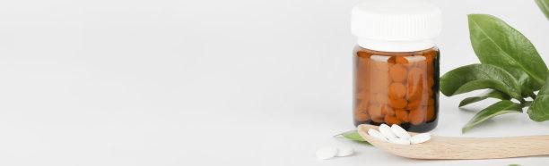 玻璃瓶中草药，木勺和白色背景的绿色植物。替代医学和健康生活方式的理念。副本的空间。横幅图片下载