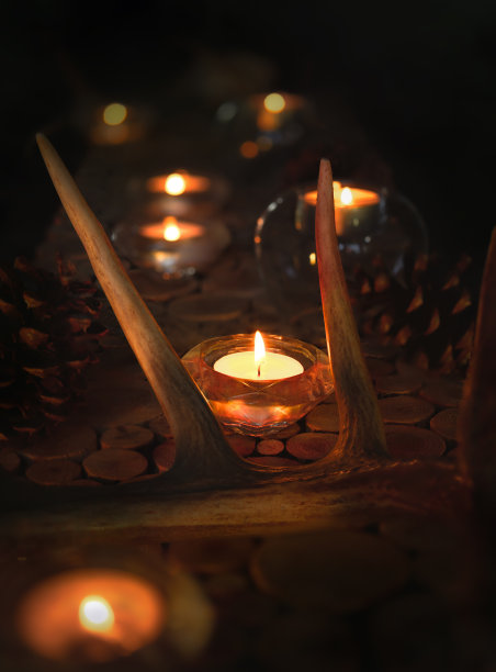 质朴的餐桌装饰蜡烛灯和鹿角，关闭。图片下载