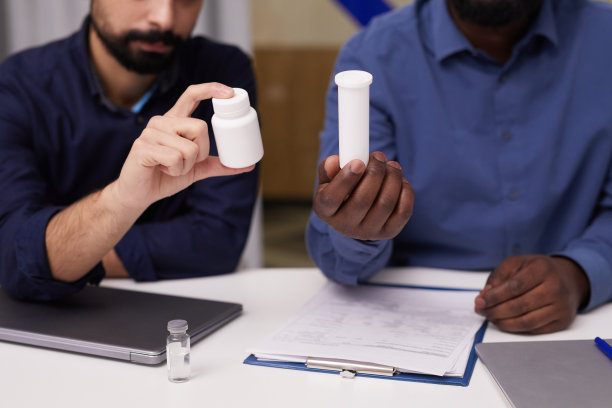 两个年轻的跨文化男性药理学家提供新的补充剂图片下载