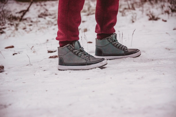 冬天，两只脚穿着靴子站在雪地里的小路上图片下载