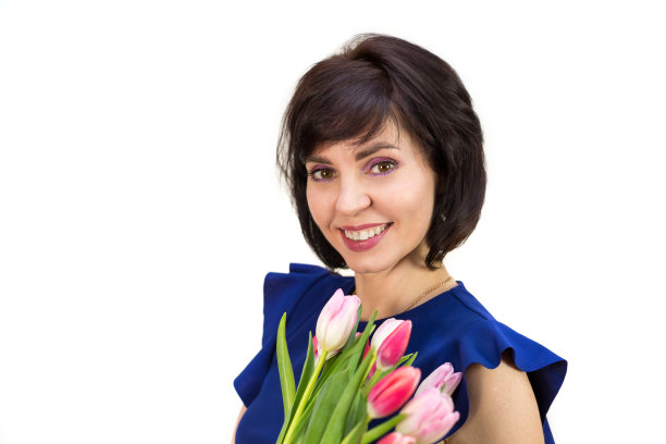 一个有着美丽微笑的黑发女人的肖像与一束明亮新鲜的郁金香，孤立的，白色的背景图片下载