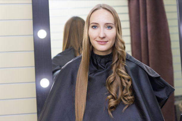 女理发师，美容院。理发师用卷发棒烫发图片下载