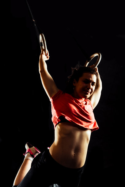 肌肉发达的小女孩在吊环上做引体向上图片下载