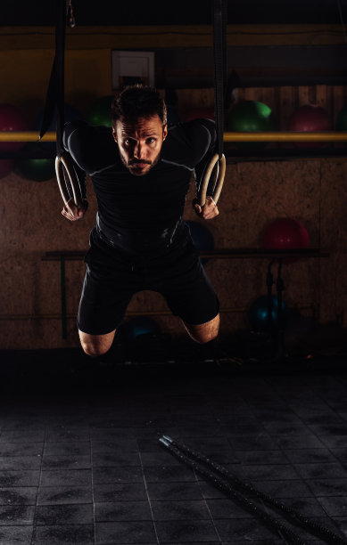 健身房里的吊环健身男挂在健身房里图片下载