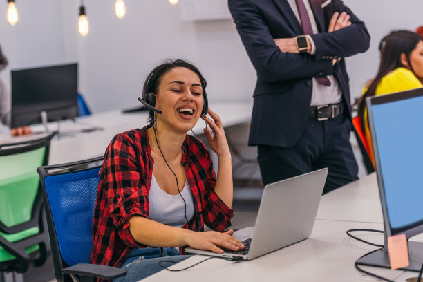 戴着耳机，使用笔记本电脑的美丽年轻女子图片下载