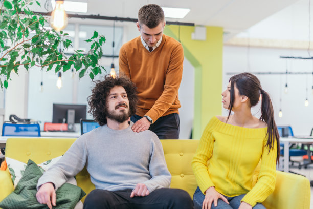 为紧张的同事按摩。商人队友给他的同事按摩。图片下载