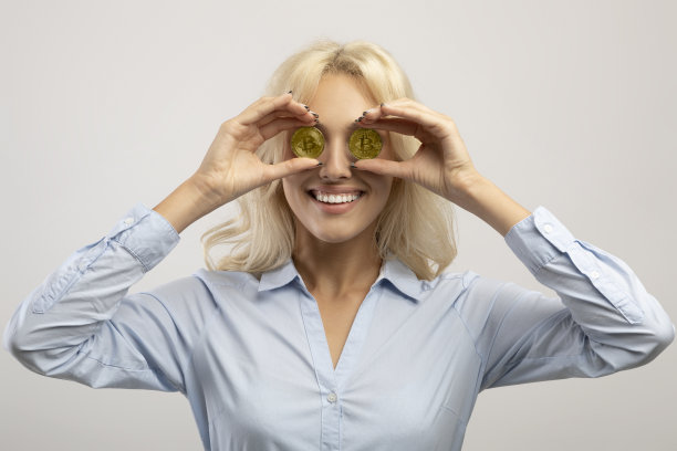 数字加密货币，股票交易的概念。幸福的女商人捧着黄金比特币，把眼睛蒙上图片下载