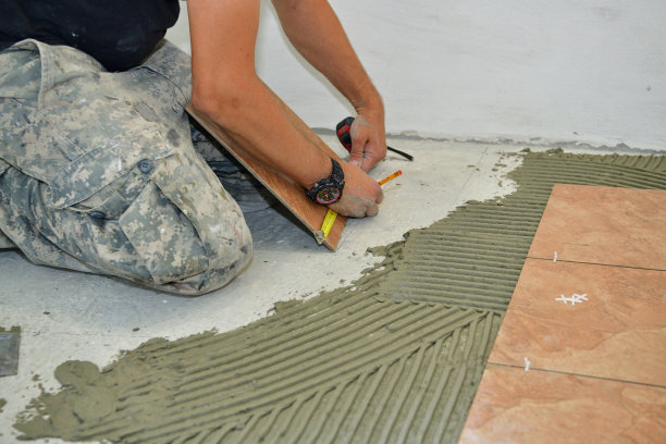 瓦工测量并把瓦片粘在房间的地板上图片下载